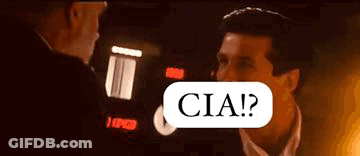 Man In Suit Talking To Another In Dark Room GIF