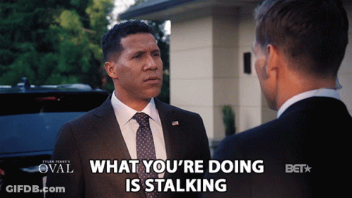 Man In Suit Talking To Another Man Saying What You're Doing Is Stalking GIF
