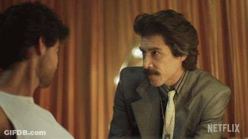 Man In Suit Talking To Another With Netflix Logo GIF