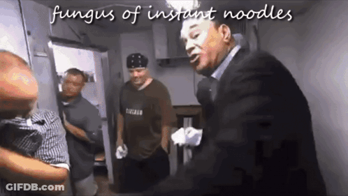 Man In Suit Talking To Man In Chicago Shirt In Kitchen GIF