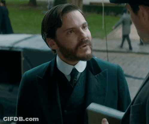 Man In Suit Talking To Man In Hat GIF