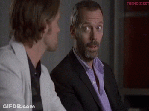 Man In Suit Talking To Man In White Jacket GIF