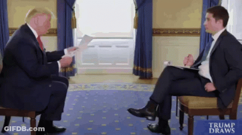 Man In Suit Talking To Man With Trump Draws Sign GIF