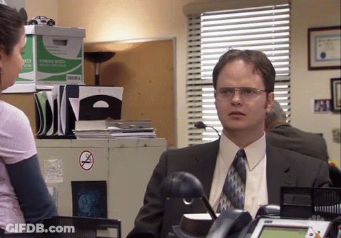 Man In Suit Talking To Woman By Storage Boxes GIF