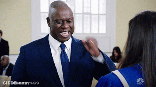 Man In Suit Talking To Woman In Graduation Gown GIF
