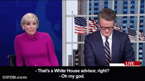 Man In Suit Talking To Woman In Pink GIF