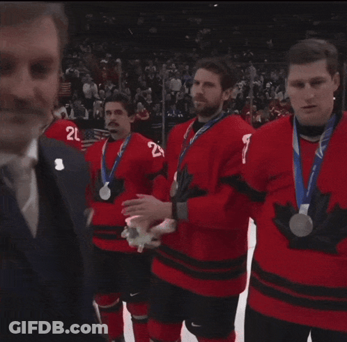 Man In Suit Talks To Hockey Players In Red A Jerseys GIF