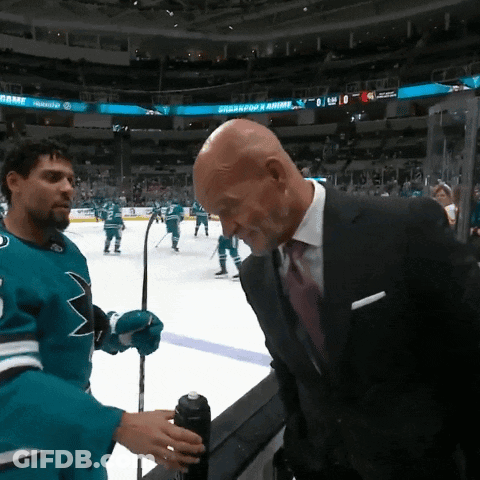 Man In Suit Talks To Man In Sharks Jersey GIF