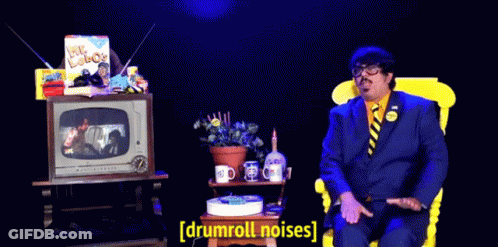 Man In Suit Tie Watching TV Drumroll Noises GIF