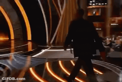 Man In Suit Walking Across Stage At Awards Show GIF