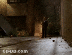 Man In Suit Walking Down Dark Alley GIF