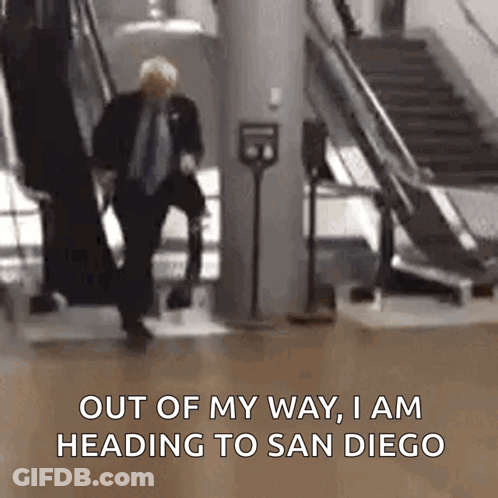 Man In Suit Walking Down Escalator Out Of My Way I Am Heading To San Diego GIF