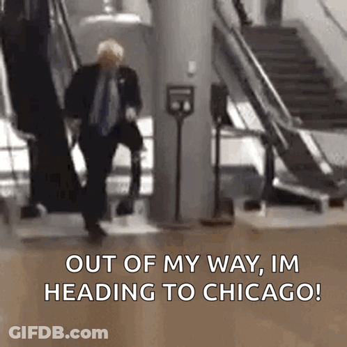Man In Suit Walking Down Escalator Says Out Of My Way I'm Heading To Chicago GIF