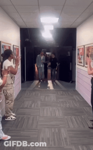 Man In Suit Walking Down Hallway People Clapping GIF
