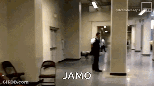 Man In Suit Walking Down Hallway With Jamo On Floor GIF