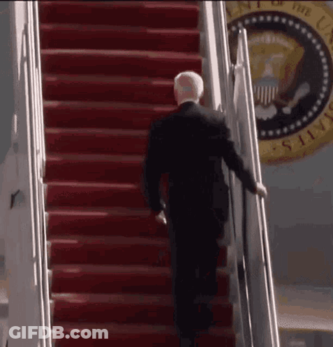 Man In Suit Walking Down Red Stairs GIF