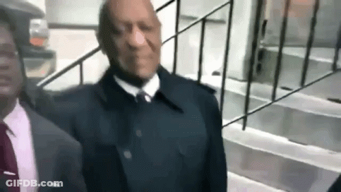 Man In Suit Walking Down Stairs Beside Railing GIF