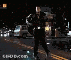 Man In Suit Walking Down Street At Night GIF