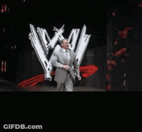 Man In Suit Walking In Front Of WWE Logo GIF