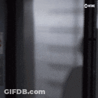 Man In Suit Walking On Wet Street At Night GIF