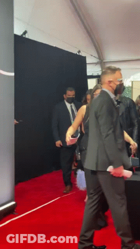 Man In Suit Walking Red Carpet With Woman GIF