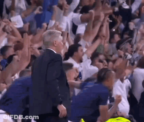Man In Suit Walking Through Crowd At Basketball Game GIF