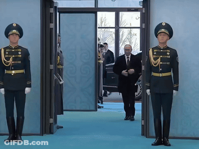 Man In Suit Walking Through Doorway With Two Soldiers GIF