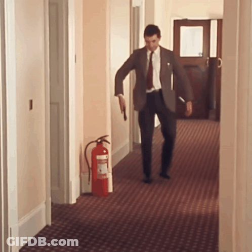 Man In Suit Walking With Fire Extinguisher GIF