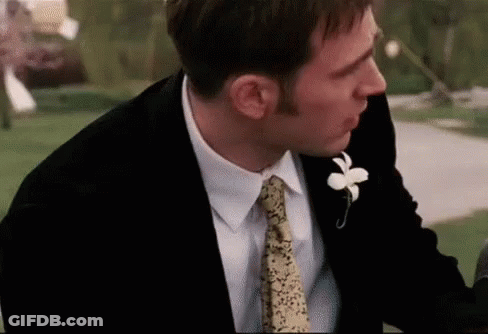 Man In Suit With Flower Lapel Looking Down GIF