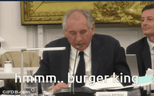Man In Suit With Microphone Saying Hmm GIF