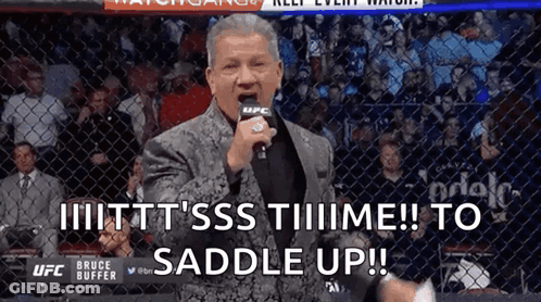 Man In Suit With Microphone Says To Saddle Up GIF