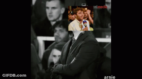 Man In Suit With Picture Behind Saying Annie GIF