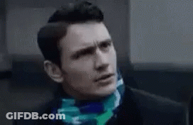 Man In Suit With Scarf Looking At Camera GIF