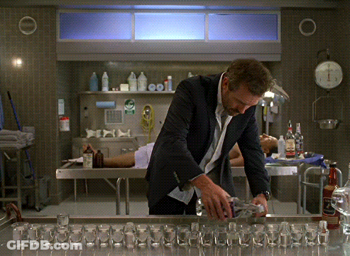 Man In Suit With Shot Glasses In Lab GIF