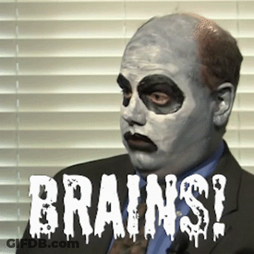 Man In Suit With White Face Saying Brains GIF