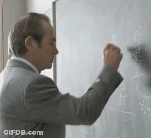 Man In Suit Writing Chinese Characters On Whiteboard GIF