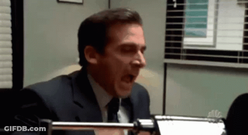 Man In Suit Yawning In Front Of NBC Sign GIF