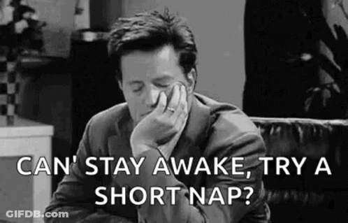 Man In Suit Yawning On Couch GIF