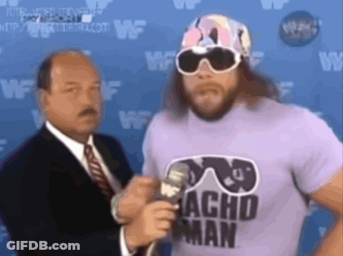 Man In Sunglasses And Acho Man Shirt Talks Into Microphone GIF