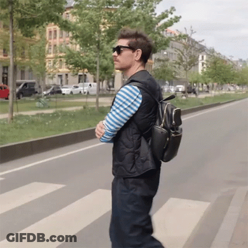 Man In Sunglasses And Black Backpack Crossing Street GIF
