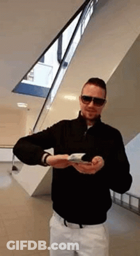 Man In Sunglasses And Black Jacket Holding Book GIF