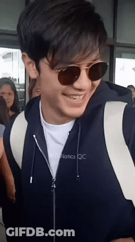 Man In Sunglasses And Black Jacket Smiles GIF