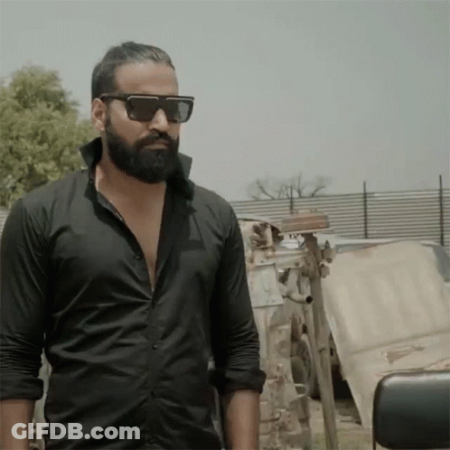 Man In Sunglasses And Black Shirt In Front Of Fence GIF