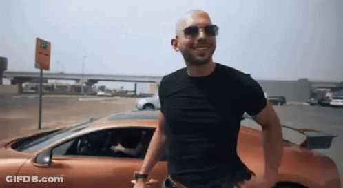 Man In Sunglasses And Black Shirt Next To Orange Car GIF