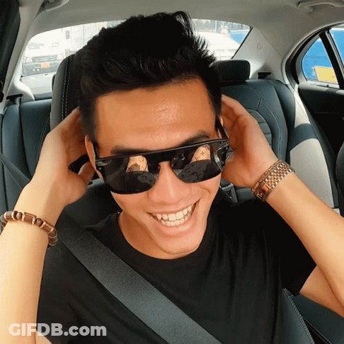 Man In Sunglasses And Black Shirt Smiling In Car GIF