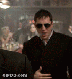 Man In Sunglasses And Black Suit Talking In Bar GIF