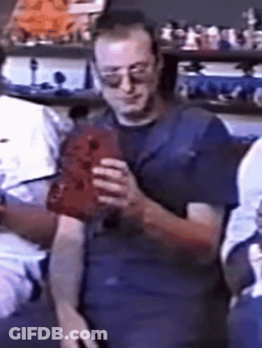 Man In Sunglasses And Blue Shirt Holding Red Object GIF
