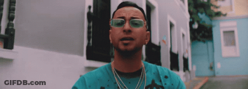 Man In Sunglasses And Blue Shirt In Front Of Buildings GIF