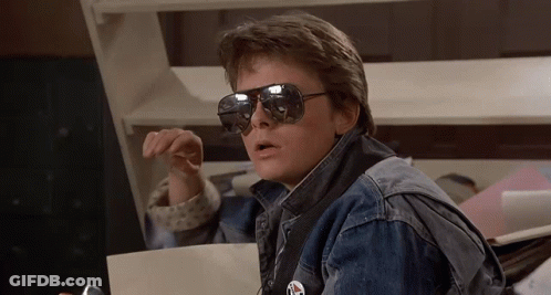 Man In Sunglasses And Denim Jacket Holding Paper GIF