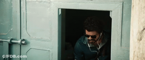 Man In Sunglasses And Earbuds At Doorway GIF